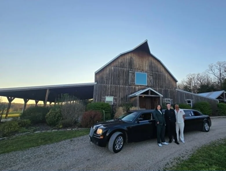 Family with their son standing in front of The Executive stretch limo at a rustic Ozarks barn — Unique Rides Transportation Springfield MO